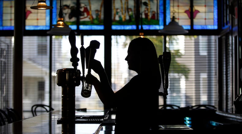 Emily Stephens, the catering manager at The Amber Rose Restaurant and Catering, a Dayton institution specializing in homemade Eastern European cuisine, pours a beer. LISA POWELL / STAFF