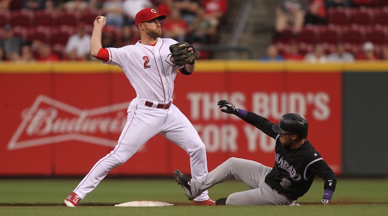 Reds shortstop Zack Cozart throws to first to complete a double play against the Rockies on Friday, May 19, 2017, at Great American Ball Park in Cincinnati.