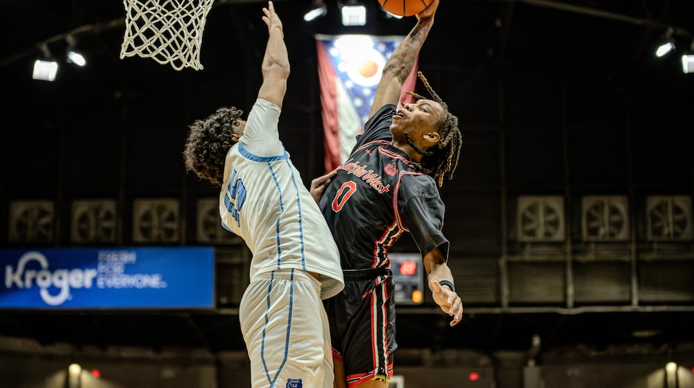 Lakota West junior Bryce Curry leaps for a dunk while being defended by Olentagy Berlin's Brayden Green during a Division I regional semifinal game on Thursday, March 12, 2026 at the Ohio Expo Center's Taft Coliseum. MICHAEL COOPER / STAFF