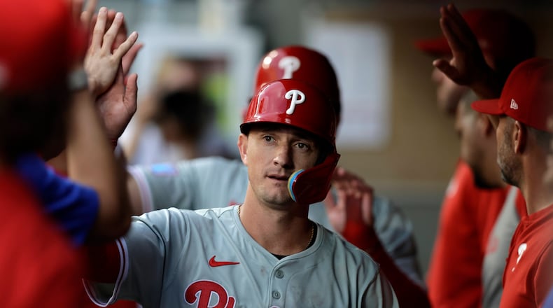 Philadelphia Phillies' Austin Hays makes his way through the dugout with Kyle Schwarber after scoring against the Seattle Mariners during the fifth inning in a baseball game, Saturday, Aug. 3, 2024, in Seattle. (AP Photo/John Froschauer)