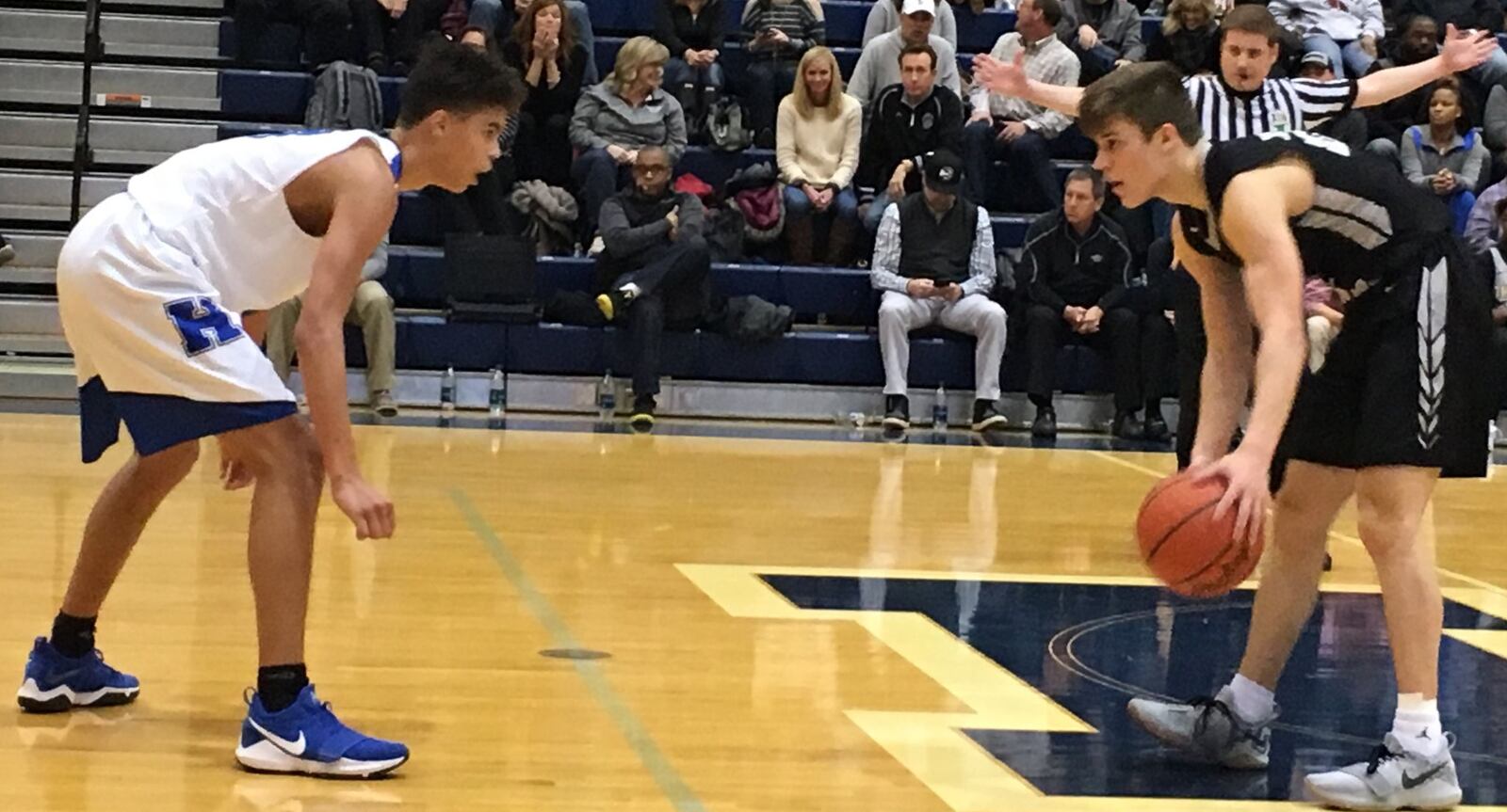 Hamilton’s Trey Robinson (20) and Lakota East’s Will Johnston (24) go eye to eye Friday night at the Hamilton Athletic Center. RICK CASSANO/STAFF