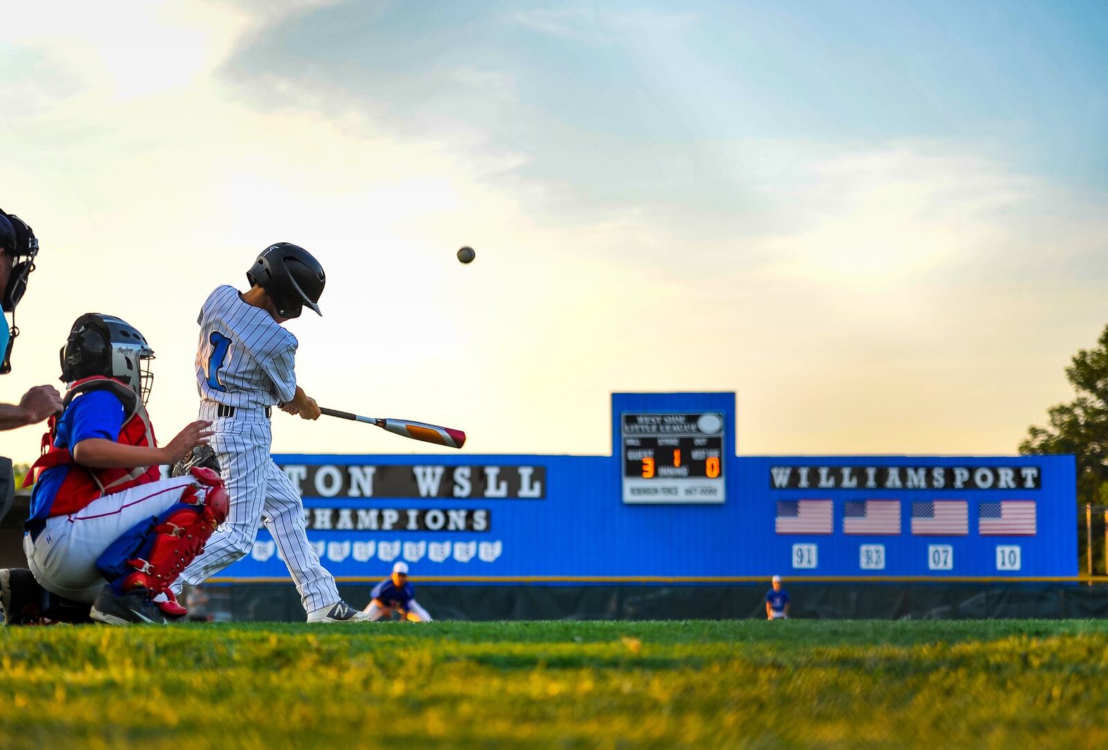 Hamilton West Side’s Clint Moak doubles during a 15-0 victory over Hamilton-Fairfield in Thursday night’s Little League District 9 title game at West Side. NICK GRAHAM/STAFF