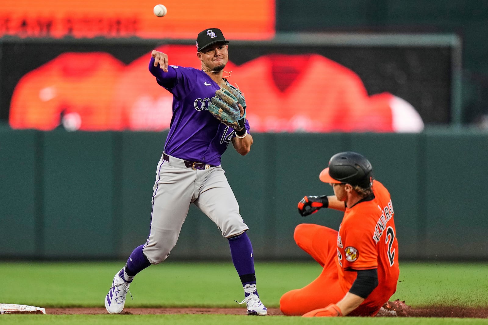 Colorado Rockies shortstop Ezequiel Tovar (14) turns a double play as Baltimore Orioles' Gunnar Henderson (2) is forced out at second base during the third inning of a baseball game, Saturday, July 26, 2025, in Baltimore. (AP Photo/Stephanie Scarbrough)