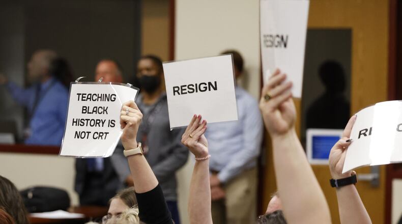Attendees hold up signs during the Lakota Board of Education meeting that lasted over three hours Monday night, May 9, 2022, at Lakota Plains Junior School. NICK GRAHAM/STAFF