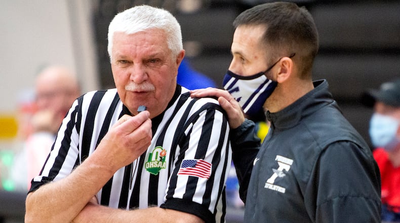 Veteran official Bill Trent talks with Fairmont coach Kenny Molz during the fourth quarter of Friday night's Division I sectional game at Centerville High School. Trent was working his final game to conclude a 40-year officiating career. Jeff Gilbert/CONTRIBUTED