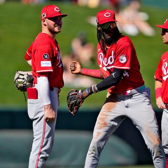 From left; Cincinnati Reds' Gavin Lux, Elly De La Cruz, Matt McLain, and Christian Encarnacion-Strand talk during a pitching change against the Los Angeles Angels during the second inning of a spring training baseball game, Wednesday, Feb. 26, 2025, in Tempe, Ariz. (AP Photo/Matt York)
