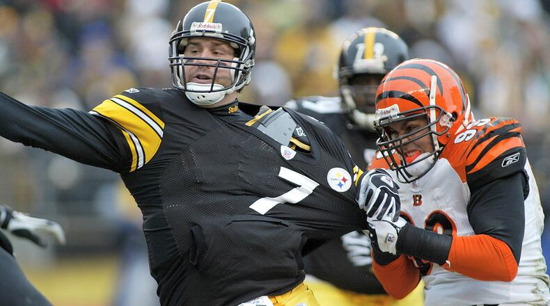 PITTSBURGH, PA- DECEMBER 4: Ben Roethlisberger #7 of the Pittsburgh Steelers throws the ball away as David Pollack #99 of the Cincinnati Bengals tries to sack him on December 4, 2005 at Heinz Field in Pittsburgh, Pennsylvania. (Photo by Rick Stewart/Getty Images)