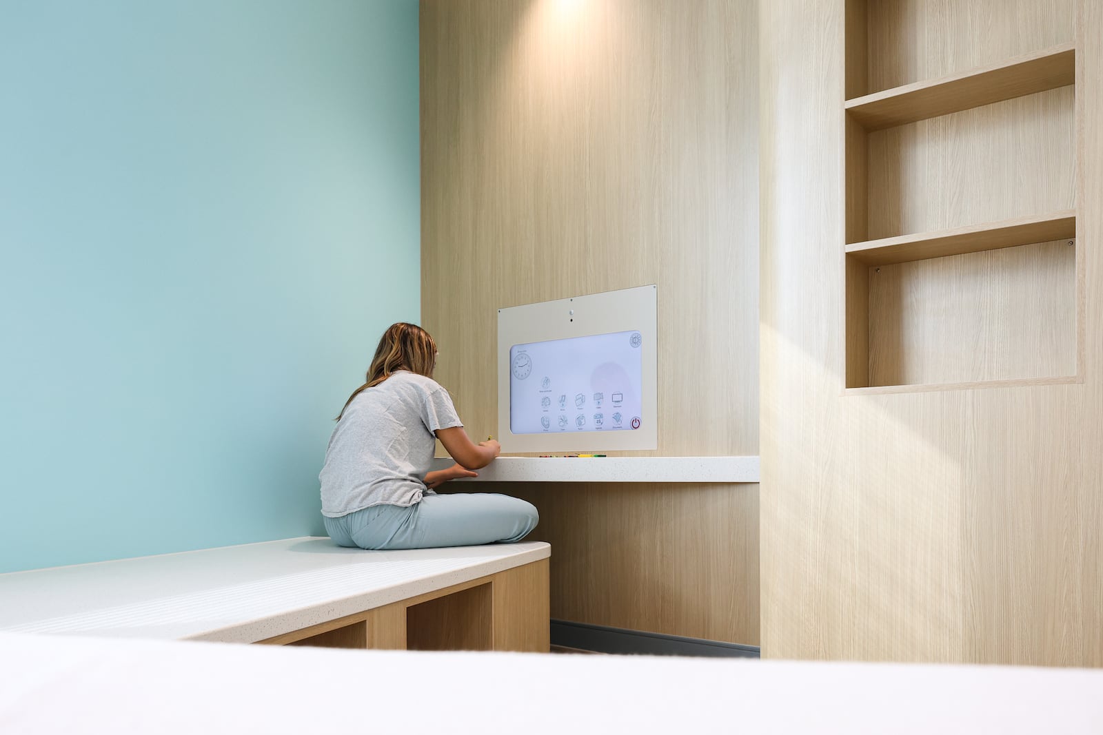 Eleanor Hake, an intern for Dayton Children's, colors while posing a patient to demonstrate functionality in a room at Dayton Children's Mathile Center for Mental Health and Wellness during a tour on Monday morning. The center will start serving patients in July. BRYANT BILLING / STAFF