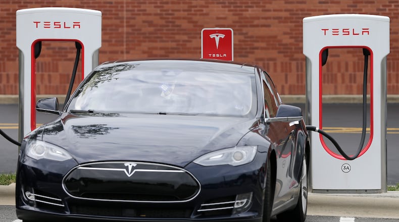 In this Saturday, June 24, 2017, photo, a Tesla car recharges at a charging station in Charlotte, N.C. AP Photo/Chuck Burton
