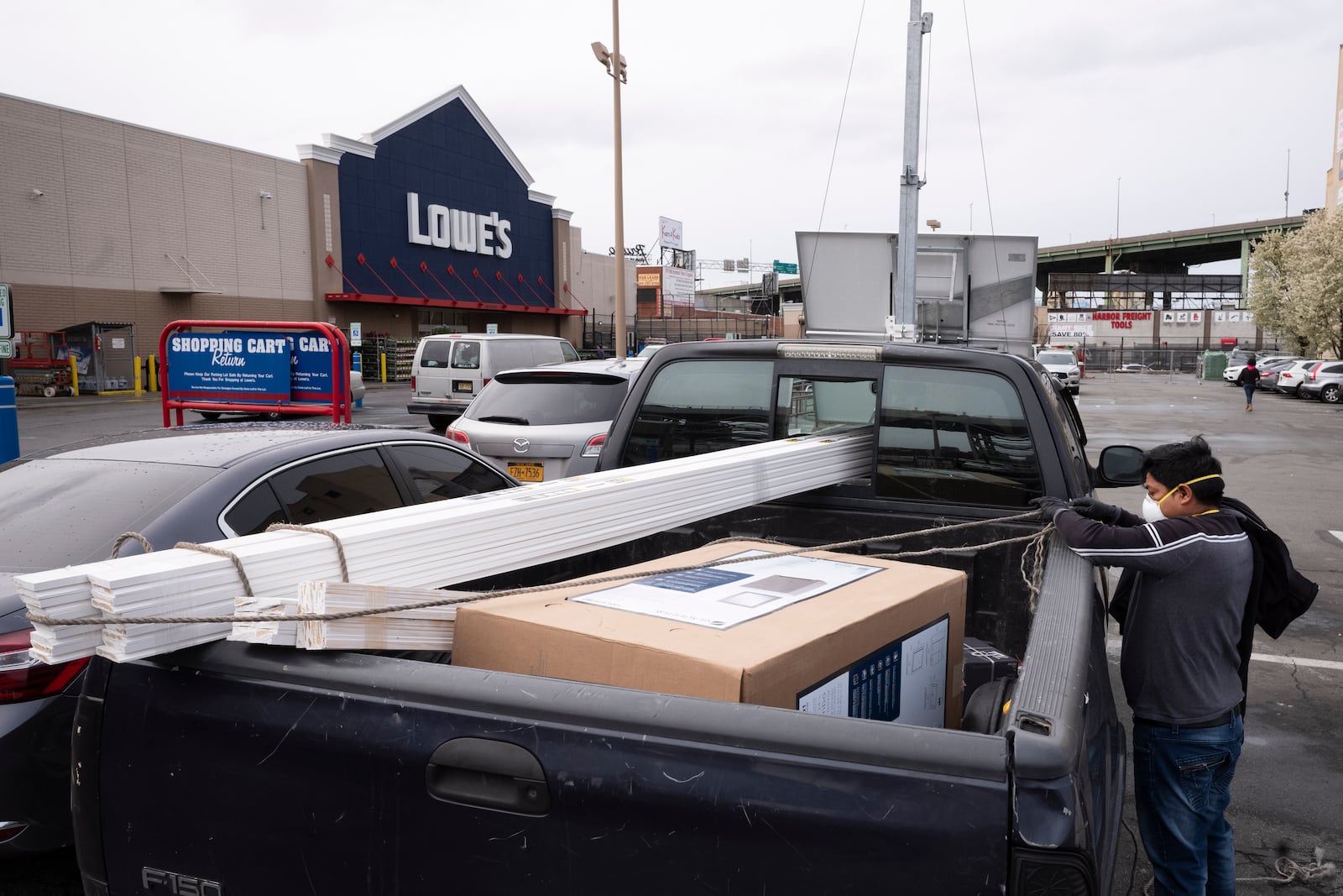 FILE - Lowe's customers wear masks as they load building supplies into their truck, Friday, April 3, 2020, during the coronavirus pandemic in New York. (AP Photo/Mark Lennihan, File)