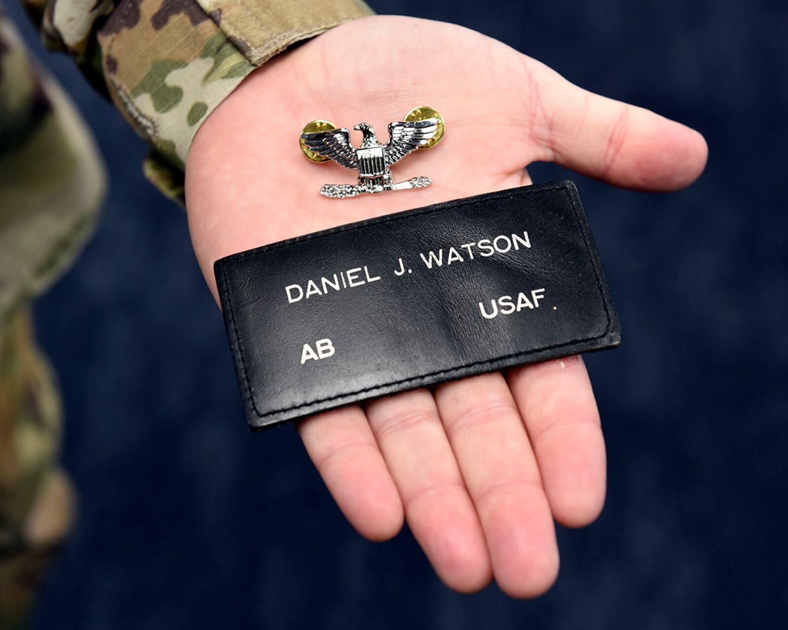 Lt. Col. Dan Watson, chief of Air Force Materiel Command’s Acquisition Law Division, holds a colonel’s insignia and the patch from his first assignment as a law enforcement specialist and military working dog handler at Wright-Patterson Air Force Base. U.S. AIR FORCE PHOTO/TY GREENLEES