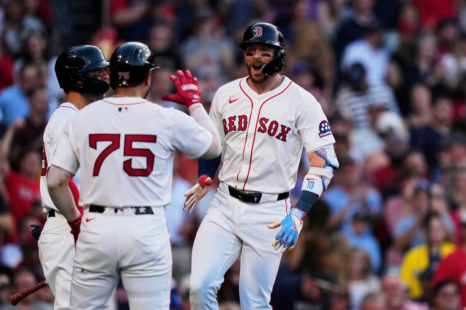 Boston Red Sox's Trevor Story, right, celebrates after his three-run home run during the first inning of a baseball game against the Cincinnati Reds at Fenway Park, Monday, June 30, 2025, in Boston. (AP Photo/Charles Krupa)