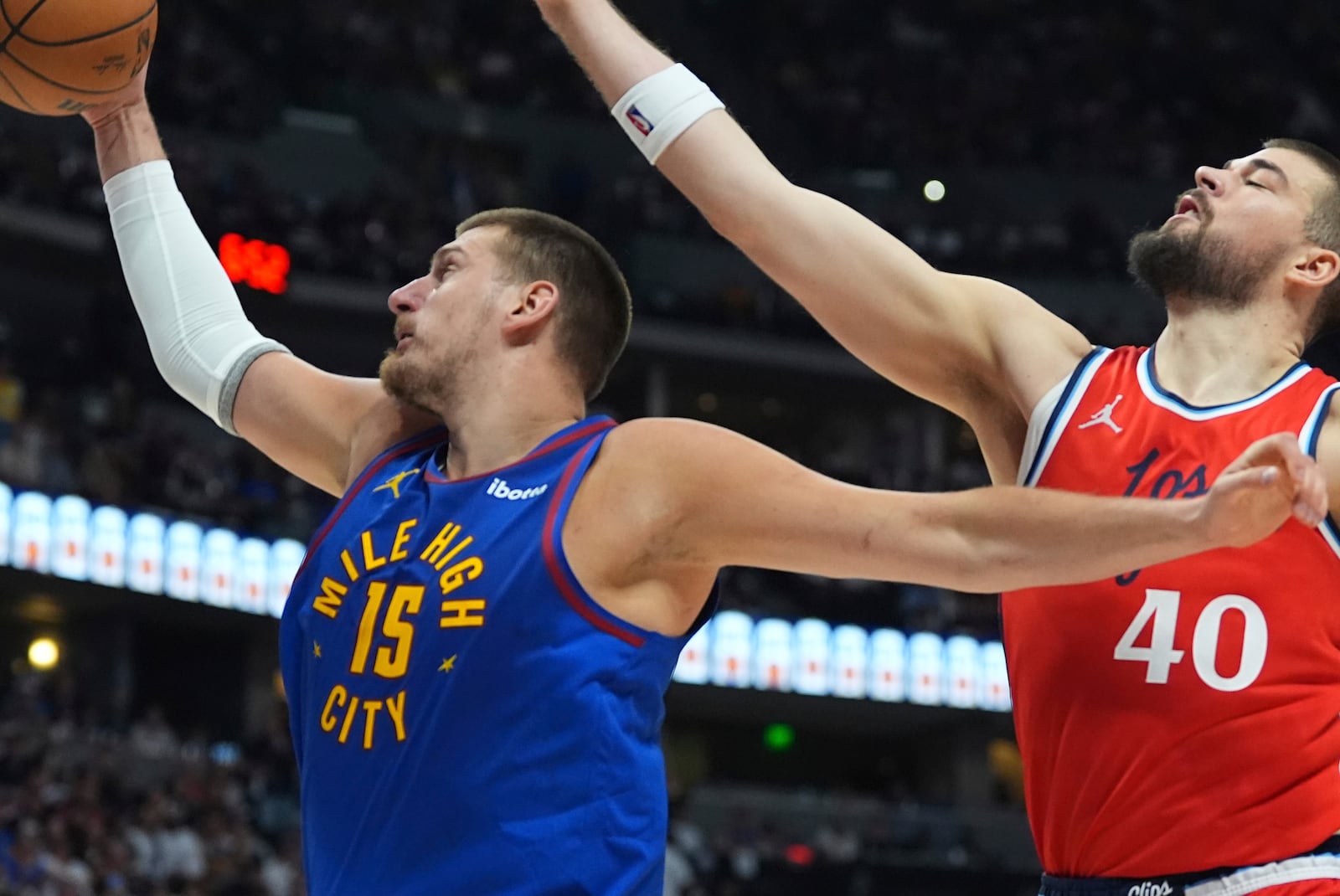 Denver Nuggets center Nikola Jokic, left, pulls in a rebound as Los Angeles Clippers center Ivica Zubac, right, defends in the second half of Game 7 of an NBA basketball first-round playoff series Saturday, May 3, 2025, in Denver. (AP Photo/David Zalubowski)