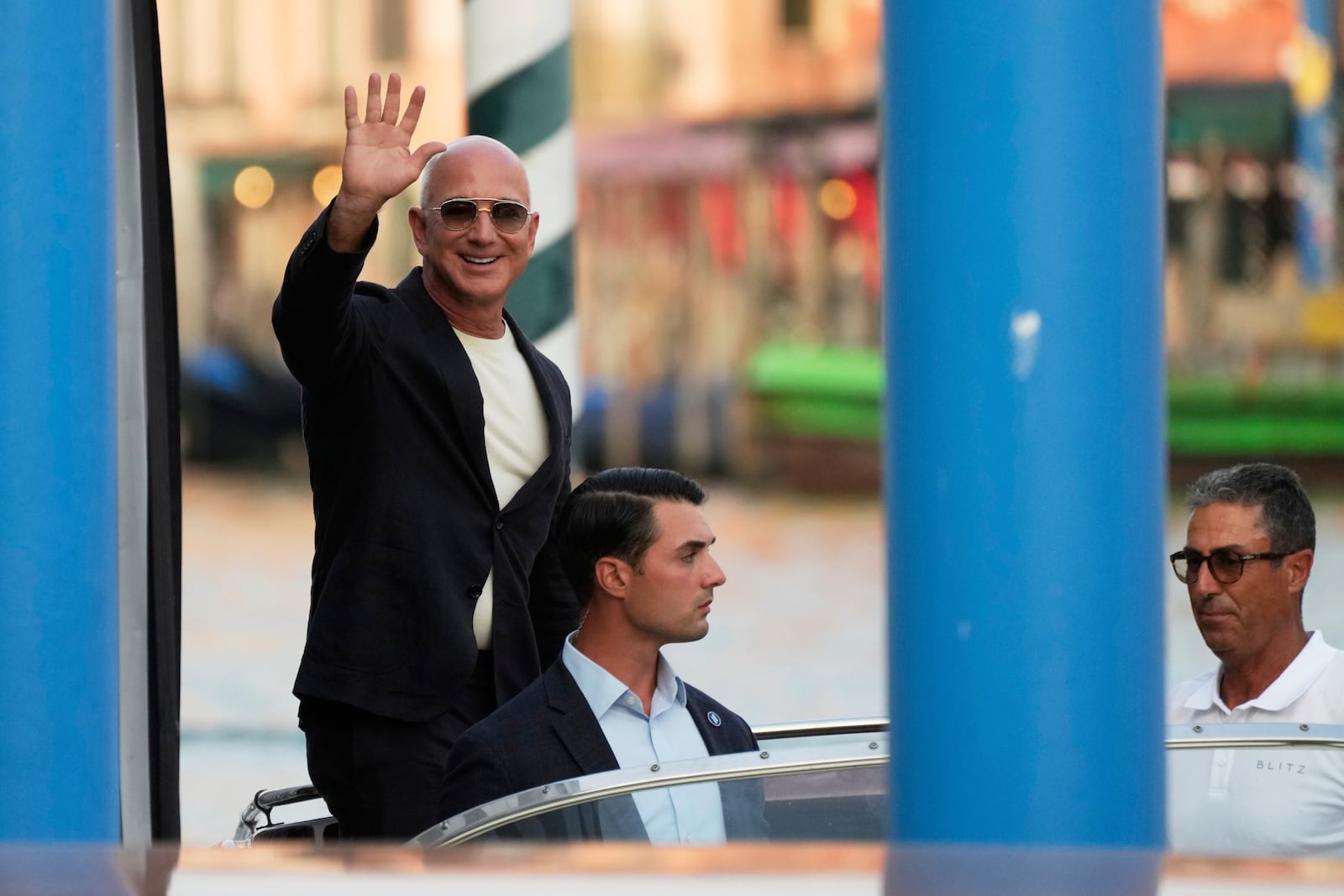 Amazon multi-billionaire founder Jeff Bezos waves as he leaves by boat an hotel in Venice, Italy, on Wednesday, June 25, 2025, ahead of festivities in the lagoon city reportedly linked to his wedding with Lauren Sanchez. (AP Photo/Luca Bruno)