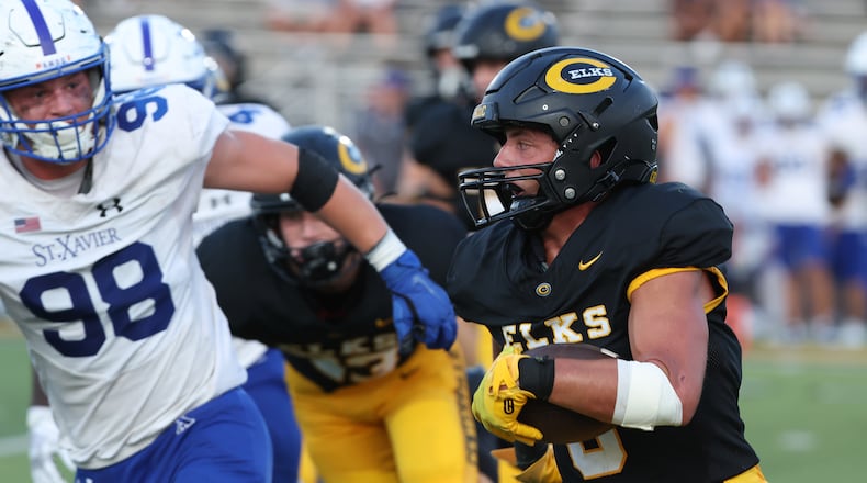 Centerville's Andrew Erwin carries the ball into the St. Xavier secondary during Friday's game. BILL LACKEY/STAFF
