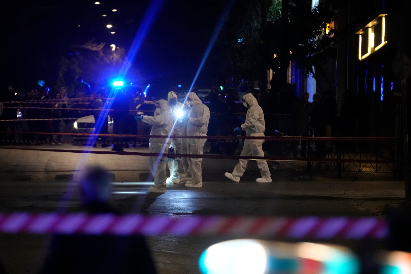 Police officers from the forensics department check the area after a bomb explosion outside of the Hellenic Train offices the company that runs Greece's railway, in Athens, Greece, Friday, April 11, 2025. (AP Photo/Petros Giannakouris)