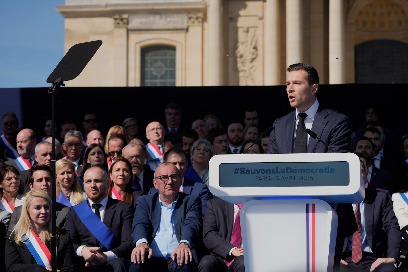 The leader of France's National Rally (RN) Jordan Bardella delivers his speech during the French far-right party national rally near the parliament in support of Marine Le Pen in Paris, Sunday, April 6, 2025. (AP Photo/Michel Euler)