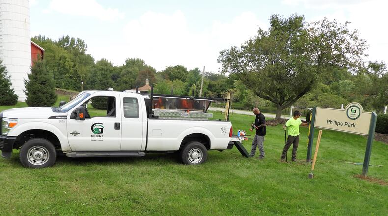 Greene County Parks & Trails Maintenance Lead Grant Burtch checks the new Phillips Park sign to make sure it’s level. CONTRIBUTED