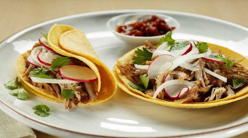 Radish, onion and cilantro top duck carnitas tacos, with the meat crisped up in a skillet after slow and low roasting. (Joan Moravek/food styling) (Chris Walker/Chicago Tribune/TNS)