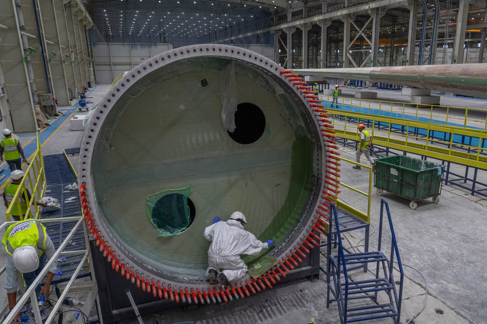 FILE - Employees work on a wind turbine blade at the Adani New Industries Limited in the port town of Mundra in Western India's Gujarat state, India, Sept. 20, 2023. (AP Photo/Rafiq Maqbool, File)