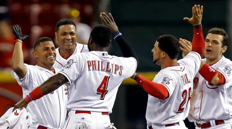 Cincinnati Reds' Cesar Izturis, left, is mobbed by teammates after he drove in the winning run with a single off Chicago Cubs relief pitcher Michael Bowden in the bottom of the 13th inning of a baseball game, Monday, April 22, 2013, in Cincinnati. Cincinnati won 5-4. (AP Photo/Al Behrman)