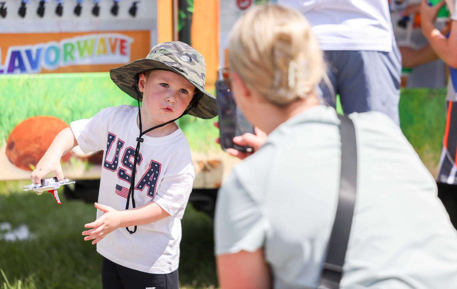 Austin Lochard, of Sidney, plays with a model Air Force Thunderbird model while his mother Nicole Lochard takes pictures during the Centerpoint Energy Dayton Air Show on Sunday, June 22. The Lochard family was at the show all day on Sunday. Austin is a big fan of the Thunderbirds. BRYANT BILLING / STAFF