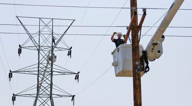 DP&L linemen repair electrical lines near Kuntz Road in Old North Dayton’s industrial park in June 2019. FILE