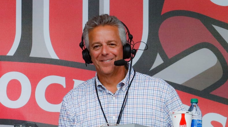 FILE - In this Sept. 25, 2019, file photo, Cincinnati Reds broadcaster Thom Brennaman sits in a special outside booth before the Reds' baseball game against the Milwaukee Brewers in Cincinnati. (AP Photo/John Minchillo, File)