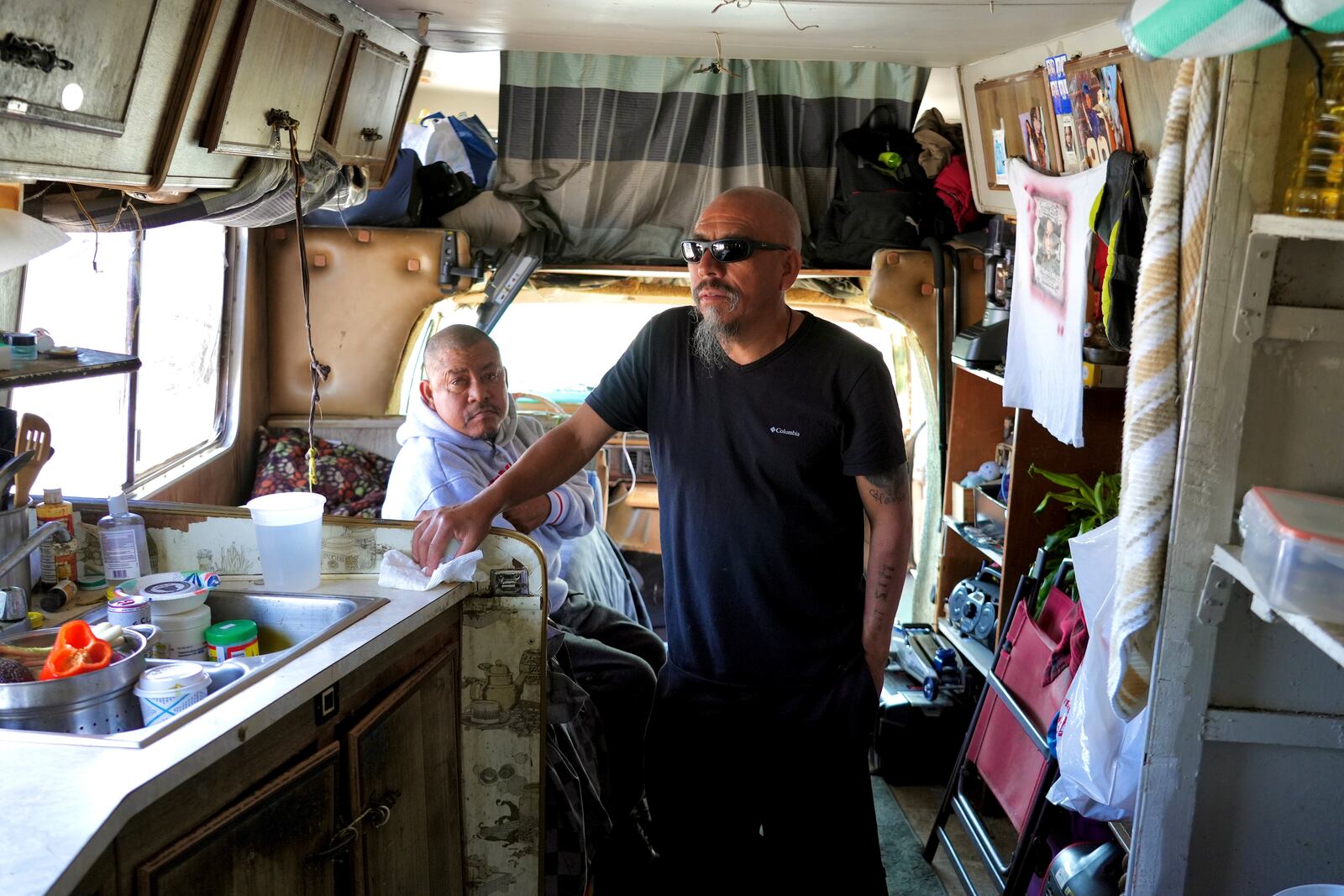 Carlos Perez stands inside an RV, where he lives with his brother, Selvin, left, in the Bayview neighborhood of San Francisco, Monday, July 14, 2025. (AP Photo/Terry Chea)
