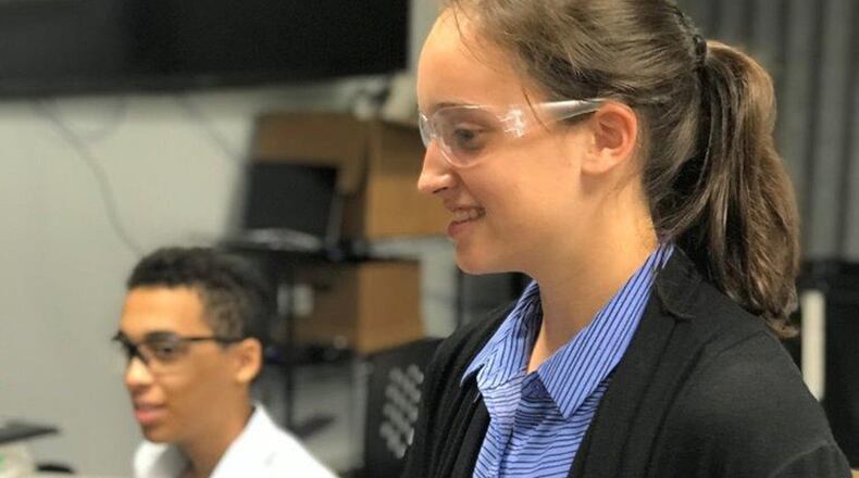 Lydia Pinsenchaum, a LEGACY junior apprentice at Wright-Patterson Air Force Base, holds a drone. She prepares to take the drone on a flight along an obstacle course, after which her team will program the drone to fly the course autonomously. (U.S. Air Force photo/Elizabeth Clinch)
