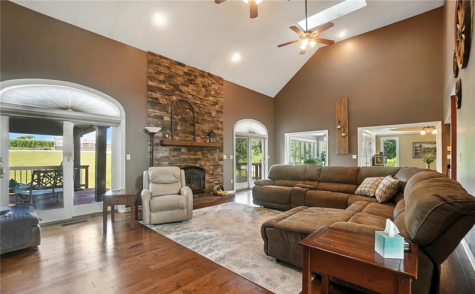 The two story great room has a floor to ceiling stone fireplace, two ceiling fans and two skylights and two sliding glass doors on either side. CONTRIBUTED