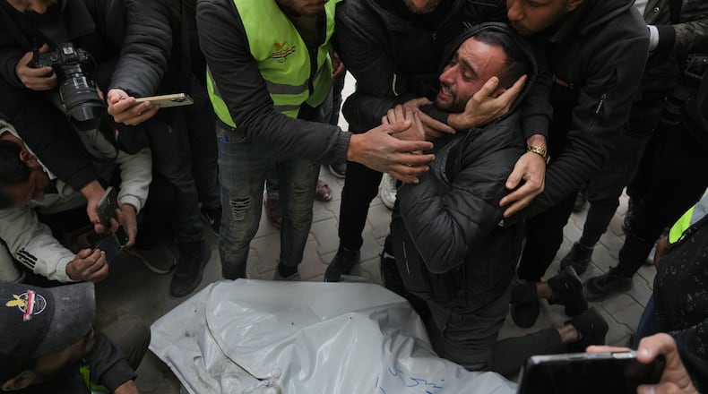 People mourn over the bodies of the Palestinian journalists Abd Shaat and Mohamed Qeshta, who were killed in an Israeli strike on a vehicle, before their funeral at Shifa Hospital, in Gaza City, Wednesday, Jan. 21, 2026. (AP Photo/Jehad Alshrafi)