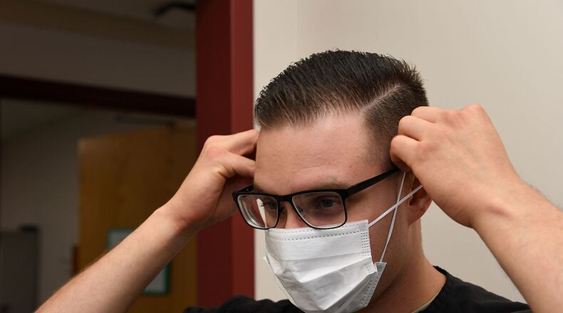 Senior Airman Alexis Lopez, dental assistant with the 319th Medical Group, demonstrates proper sanitary procedure by putting on a face mask at the medical treatment facility at Grand Forks Air Force Base, N.D., Sept. 7, 2017. Lopez said in addition to personal sanitation, there are also multiple steps taken to ensure treatment rooms are sanitary and prepared for patient use. (U.S. Air Force photo/Airman 1st Class Elora J. Martinez)