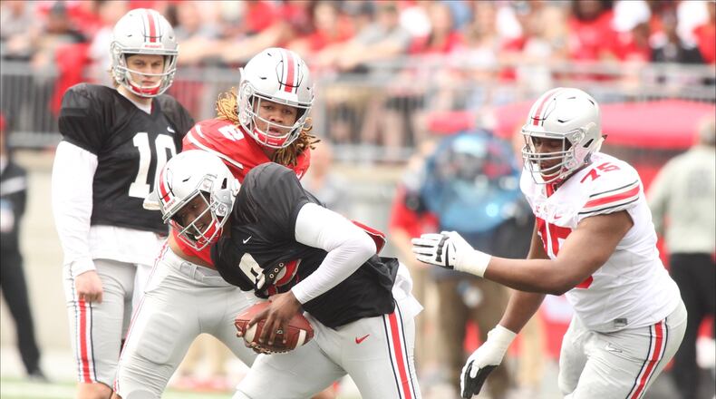 Ohio State's Dwayne Haskins tries to avoid a tackle during the spring game on Saturday, April 14, 2018, at Ohio Stadium in Columbus. David Jablonski/Staff