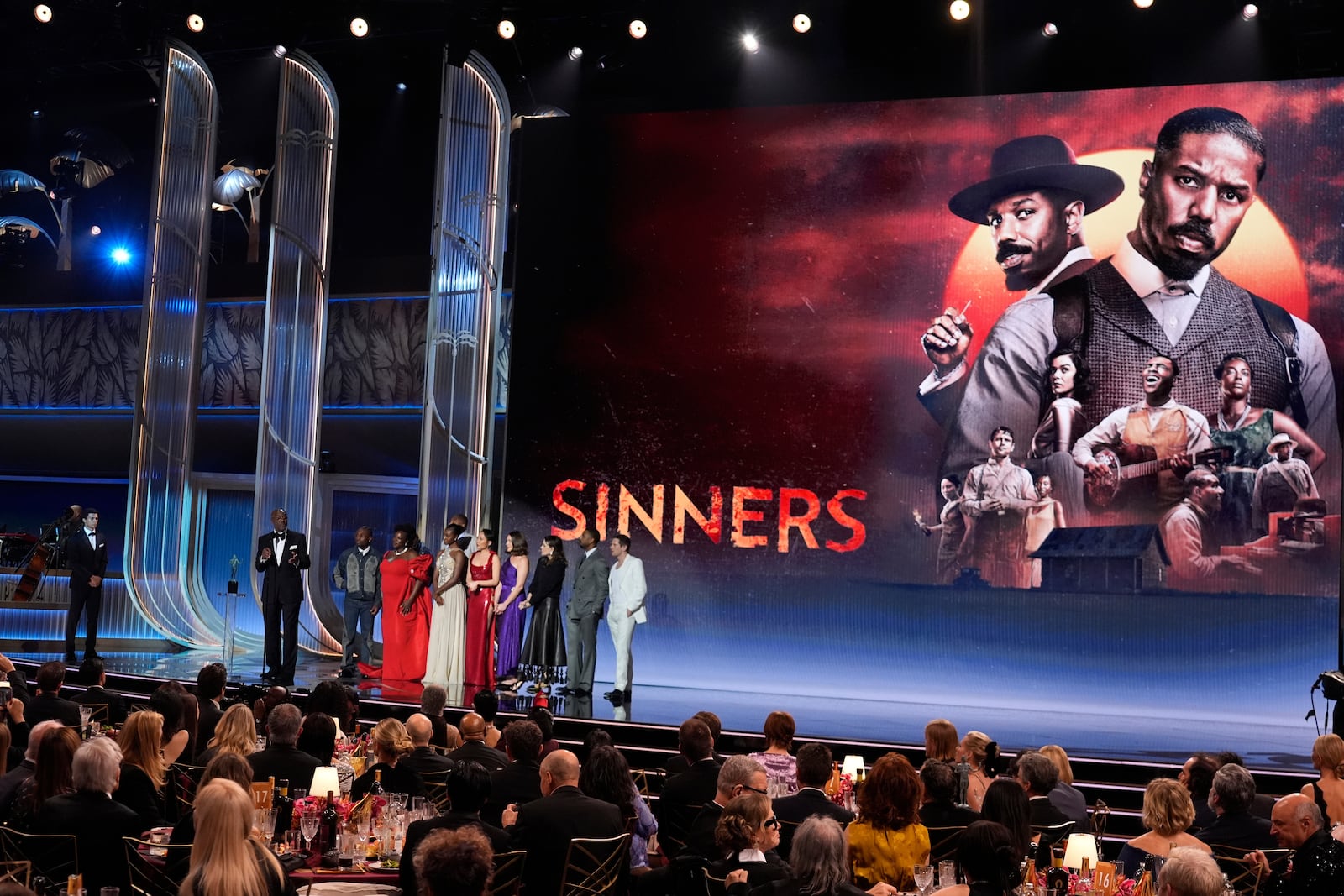 Delroy Lindo, from left, Miles Canton, Wunmi Mosaku, Omar Benson Miller, Jayme Lawson, Li Jun Li, Lola Kirke, Francine Maisler, Michael B. Jordan, and Jack O'Connell accept the award for outstanding performance by a cast in a motion picture for "Sinners" during the 32nd Annual Actor Awards on Sunday, March 1, 2026, at the Shrine Auditorium and Expo Hall in Los Angeles. (AP Photo/Chris Pizzello)