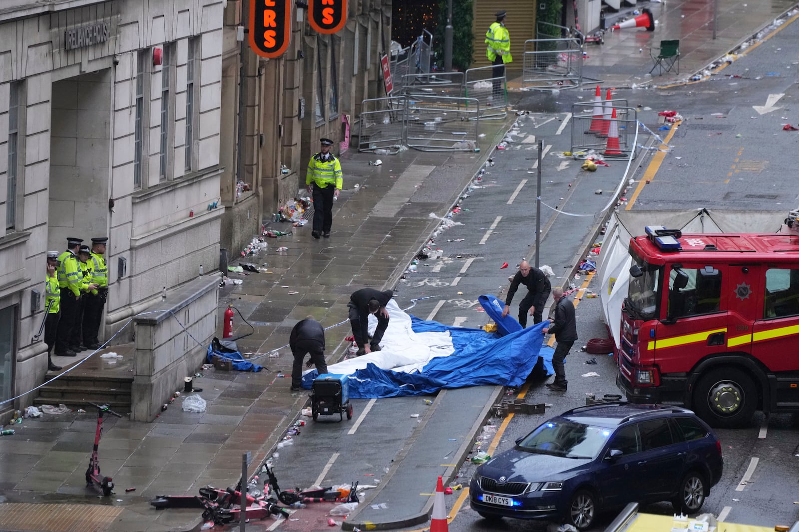 Police and emergency personnel deal with an incident after a car collided with pedestrians near the Liver Building during the Premier League winners parade in Liverpool, England, Monday, May 26, 2025.(AP Photo/Jon Super)