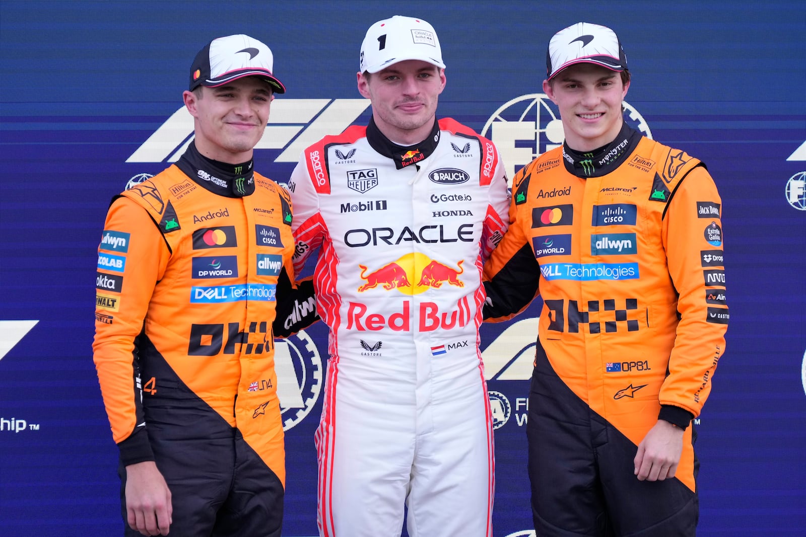 Red Bull driver Max Verstappen of the Netherlands is flanked with McLaren driver Lando Norris of Britain, left, and McLaren driver Oscar Piastri of Australia, right, after qualifying session for the Japanese Formula One Grand Prix at the Suzuka Circuit in Suzuka, central Japan, Saturday, April 5, 2025. (AP Photo/Hiro Komae)