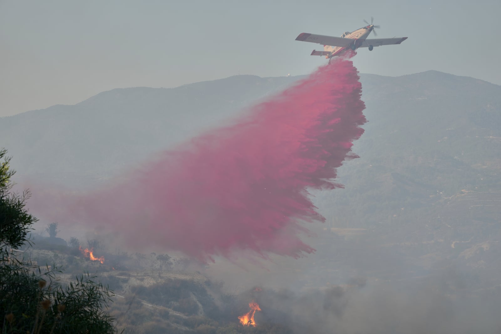 A British aircraft drops retardant liquid on the blazes in Omodos village, Cyprus, during a massive wildfire on the southern side of the east Mediterranean island nation's Troodos mountain range, Thursday, July 24, 2025. (AP Photo/Petros Karadjias)