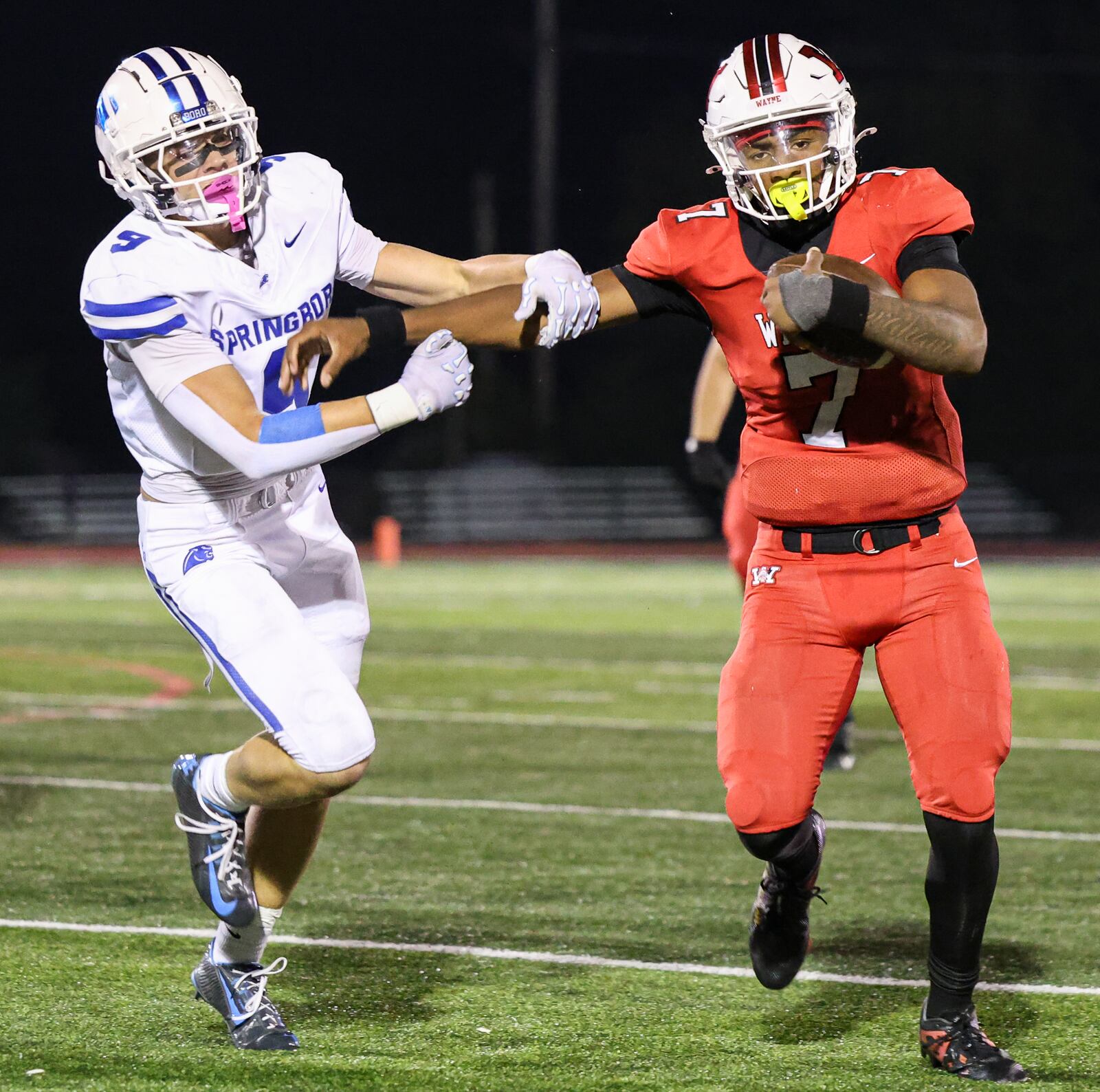 Wayne sophomore quarterback Kye Graham  fights for extra yardage with pressure from Springboro's Maddox Dixon on a run in the fourth quarter of a Greater Western Ohio Conference game on Friday at Heidkamp Stadium. Graham threw for 318 yards and four touchdowns. BRYANT BILLING / STAFF