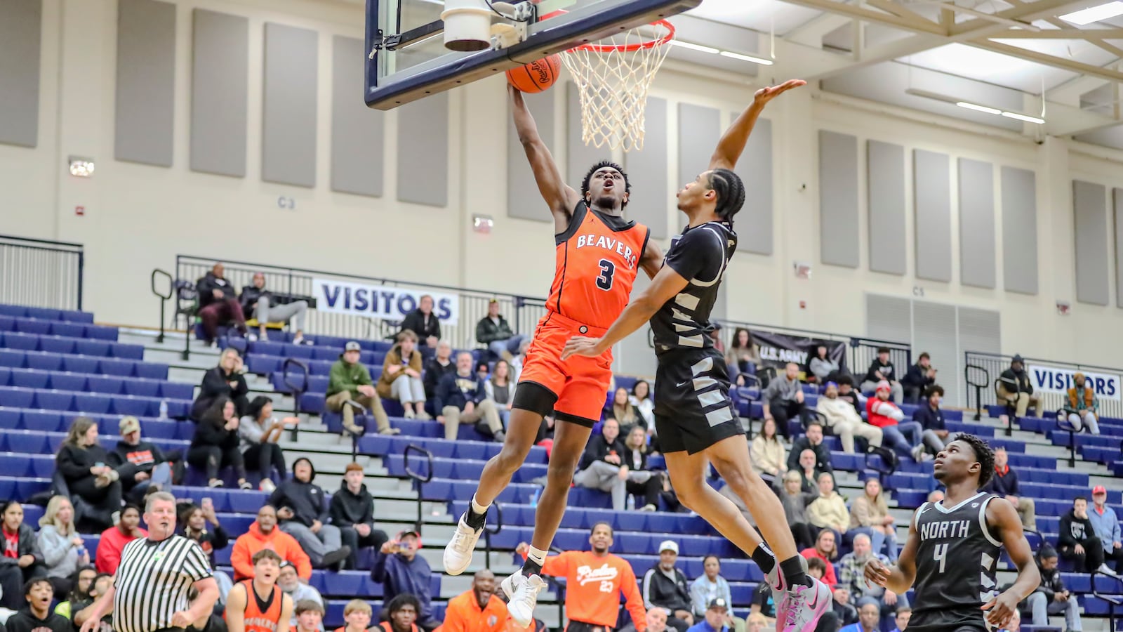 Beavercreek High School senior Kaden Ellerbe leaps to dunk the ball over Pickerington North's Favor McFadden during their game on Monday afternoon at the The Beacon Orthopaedics Flyin’ to the Hoop Invitational at Trent Arena in Kettering. Ellerbe converted the dunk, but the Beavers fell 64-56 in overtime. MICHAEL COOPER/CONTRIBUTED