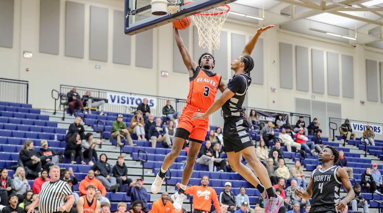 Beavercreek High School senior Kaden Ellerbe leaps to dunk the ball over Pickerington North's Favor McFadden during their game on Jan.  at the The Beacon Orthopaedics Flyin’ to the Hoop Invitational at Trent Arena in Kettering. Ellerbe converted the dunk, but the Beavers fell 64-56 in overtime. MICHAEL COOPER/CONTRIBUTED