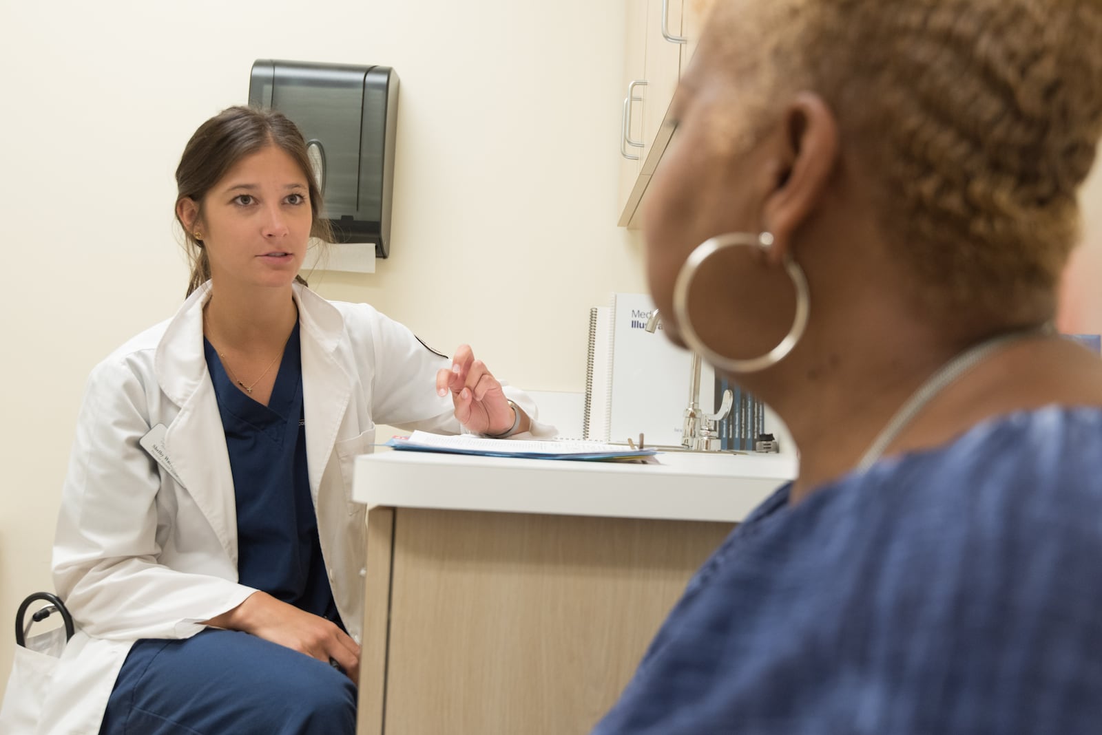 In this 2017 photo, captured inside a clinical setting, a health care provider and patient consult on influenza vaccine options. The best way to prevent seasonal flu illness, is to get vaccinated every year. CDC recommends everyone 6-months of age, and older, get a flu vaccine every season. COURTESY OF CDC