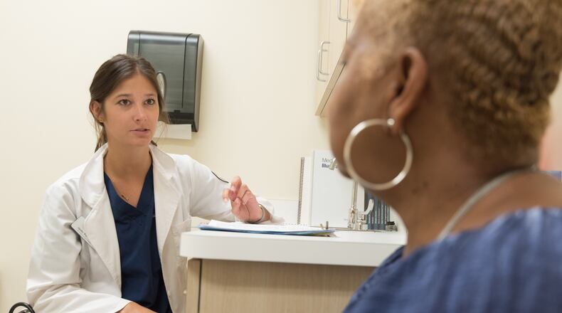 In this 2017 photo, captured inside a clinical setting, a health care provider and patient consult on influenza vaccine options. The best way to prevent seasonal flu illness, is to get vaccinated every year. CDC recommends everyone 6-months of age, and older, get a flu vaccine every season. COURTESY OF CDC