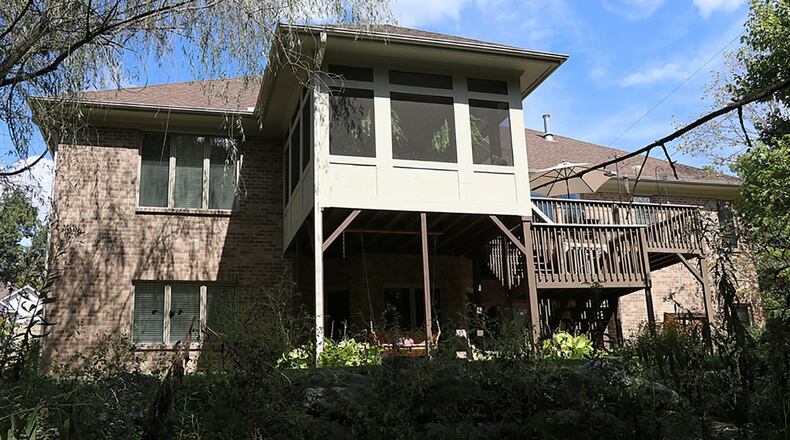 A screen-enclosed, balcony deck is accessible from the breakfast room and the main bedroom. The lower-level family room and recreation room have patio doors that open to a concrete patio.