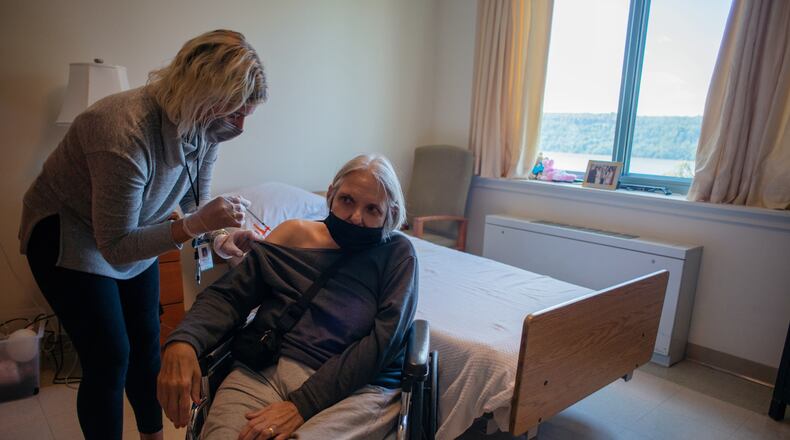 FILE — A resident gets the new bivalent Omicron booster shot at the Hebrew Home at Riverdale, a nursing care facility in the Bronx, Sept. 14, 2022. Updated booster shots have bolstered Americans’ defenses against serious COVID, reducing the risk of hospitalization by roughly 50 percent compared with certain groups inoculated with the original vaccines, the Centers for Disease Control and Prevention reported in a pair of studies published on Dec. 16. (Andrew Seng/The New York Times)