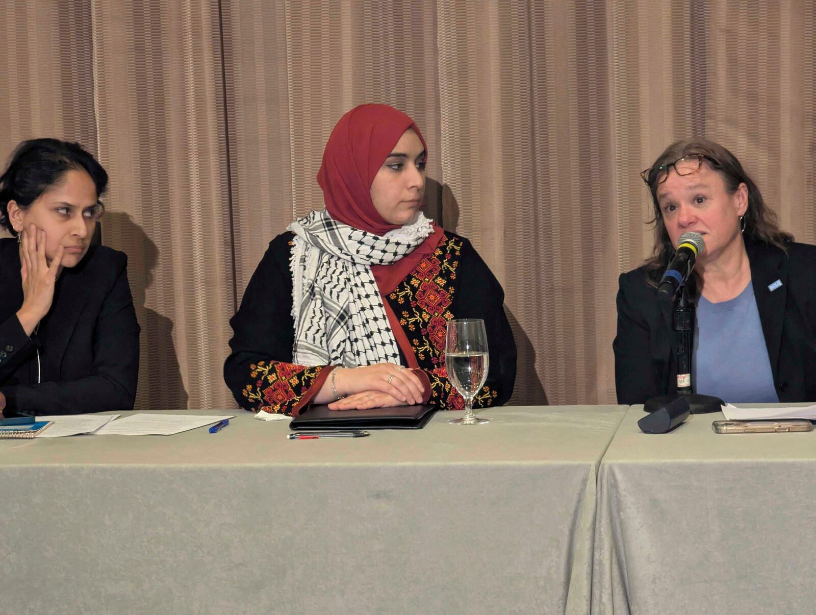 Mapheze Saleh, center, wife of arrested and detained Georgetown University scholar Badar Khan Suri, listens as senior immigrant rights attorney at ACLU Virginia Eden Heilman, right, speaks during a press conference about her husband's release following his hearing at Federal District Court for the Eastern District of Virginia, in Alexandria, Va., Thursday, May 14, 2025 (AP Photo/Nathan Ellgren)