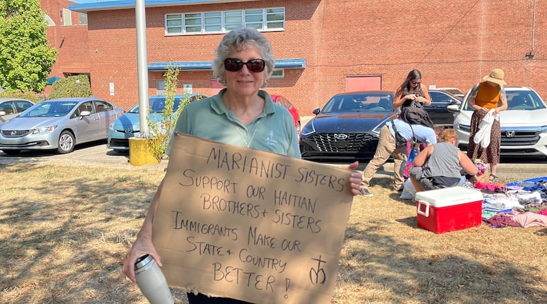 An attendee of a Dayton rally in support of Haitian Springfield residents on Sunday held a sign in support of immigrants.
