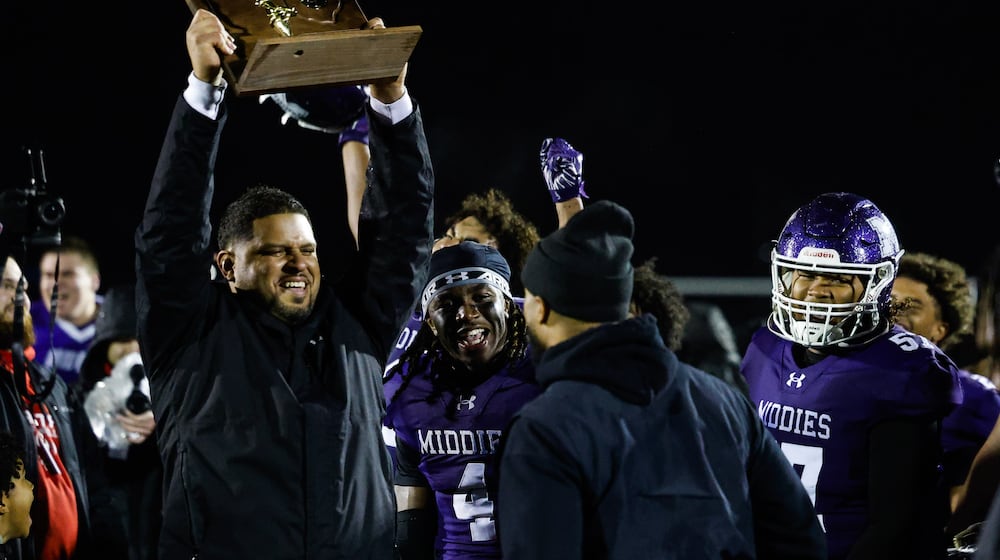 Middletown coach Kali Jones holds up the trophy after their Division I Regional football final against Wayne Friday, Nov. 21, 2025 at Trotwood Madison High School. Middletown won 21-14 to advance. NICK GRAHAM/STAFF