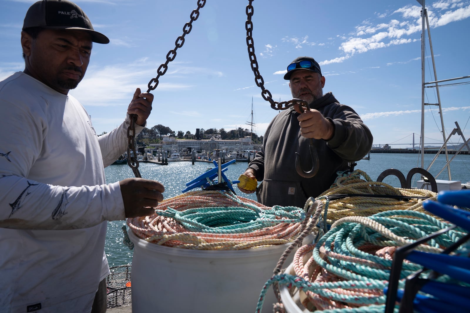 James Sanders, left, and Brand Little, load rope onto Little's boat Pale Horse at Pier 45 in San Francisco, Thursday, April 10, 2025. Little is part of a pilot program using pop-up gear to protect whales. (AP Photo/Emily Steinberger)
