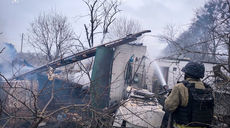 In this photo provided by the Ukrainian Emergency Service, a firefighter puts out the fire in private houses following a Russian air attack in Sumy region, Ukraine, Tuesday, Feb. 17, 2026. (Ukrainian Emergency Service via AP)